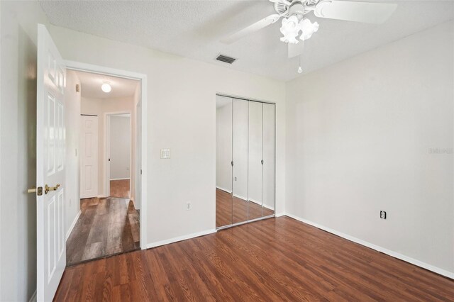 unfurnished bedroom featuring a closet, ceiling fan, hardwood / wood-style flooring, and a textured ceiling