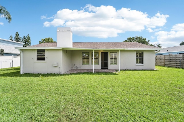 back of house with a yard and a patio