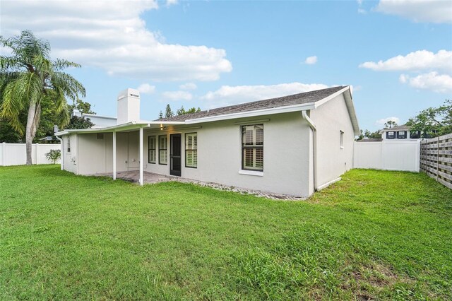 rear view of property featuring a lawn and a patio