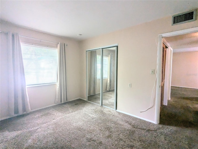 unfurnished bedroom featuring a closet and carpet flooring