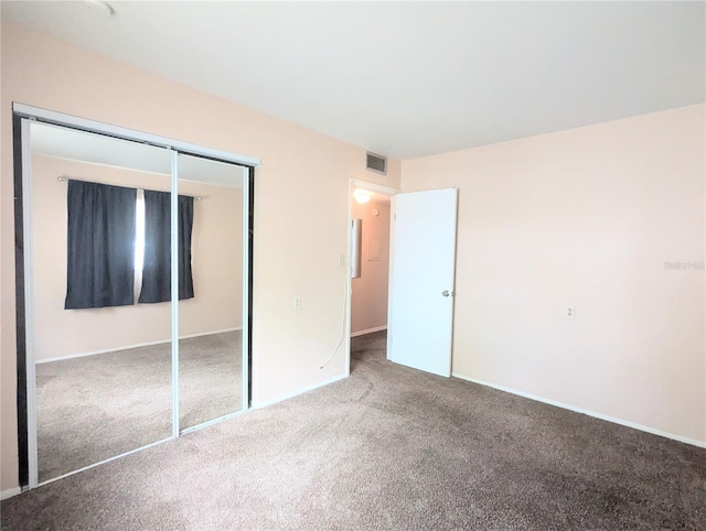 unfurnished bedroom with a closet and carpet flooring