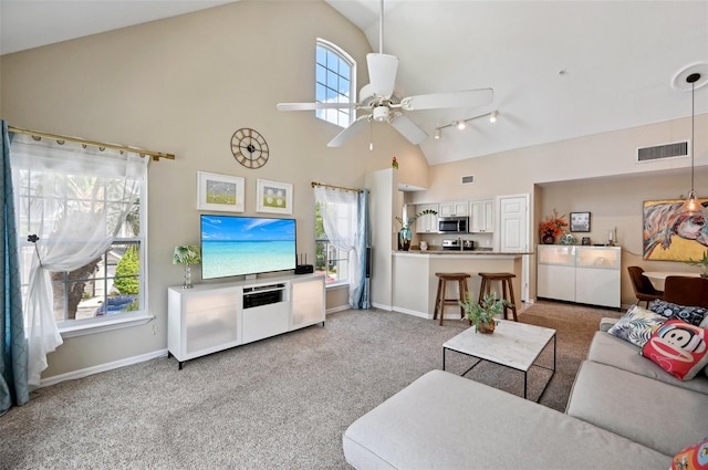 carpeted living room with high vaulted ceiling and ceiling fan