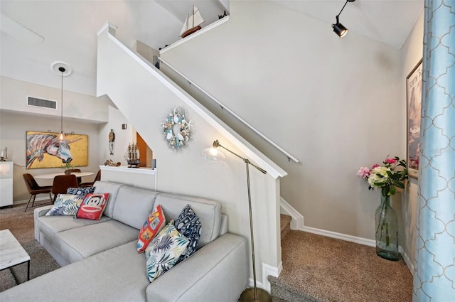 carpeted living room featuring track lighting and lofted ceiling