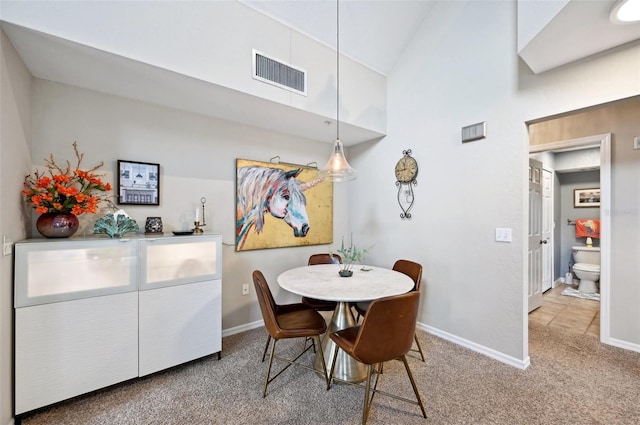 dining area with carpet and high vaulted ceiling