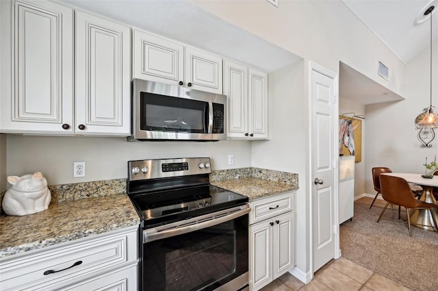 kitchen featuring appliances with stainless steel finishes, white cabinetry, and light stone countertops