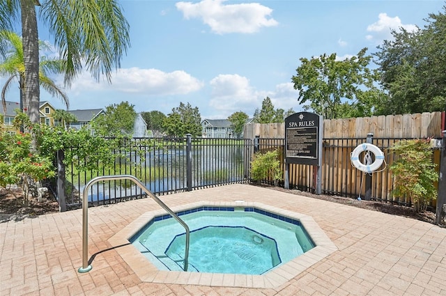 view of pool featuring a community hot tub and a water view