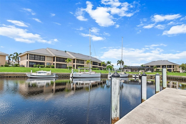 dock area with a water view and a yard