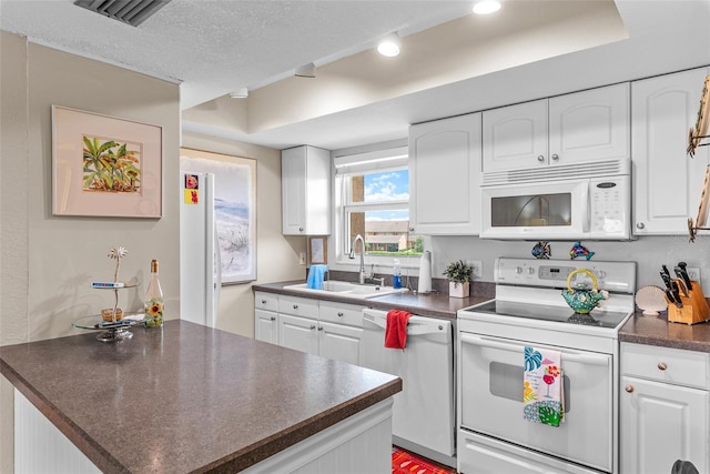 kitchen featuring a textured ceiling, sink, white appliances, and white cabinetry