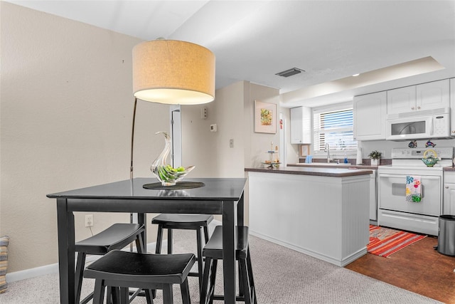 kitchen with white appliances, sink, and white cabinets