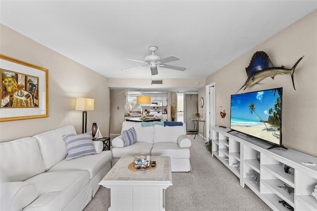 carpeted living room with ceiling fan