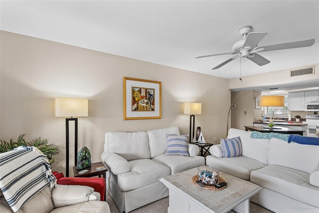 living room with ceiling fan and carpet floors