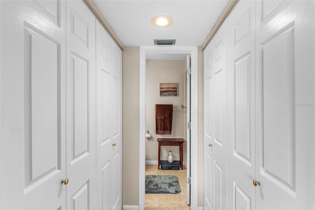 hall with tile patterned floors