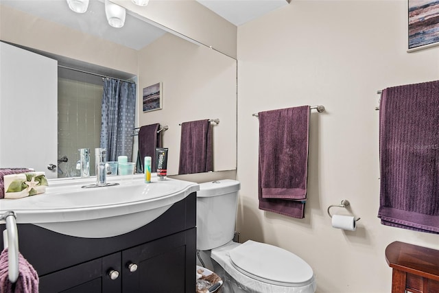 bathroom featuring vanity, toilet, and curtained shower