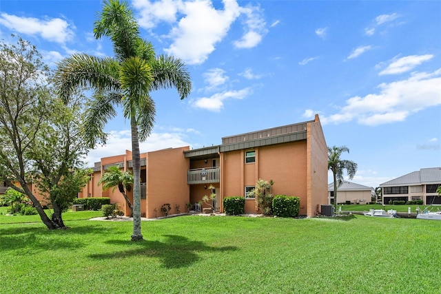 exterior space with a balcony, a lawn, and cooling unit