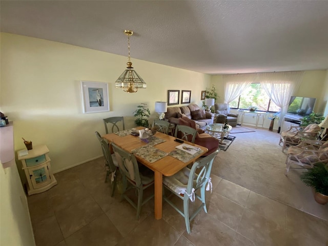 dining space with tile patterned flooring, an inviting chandelier, and a textured ceiling