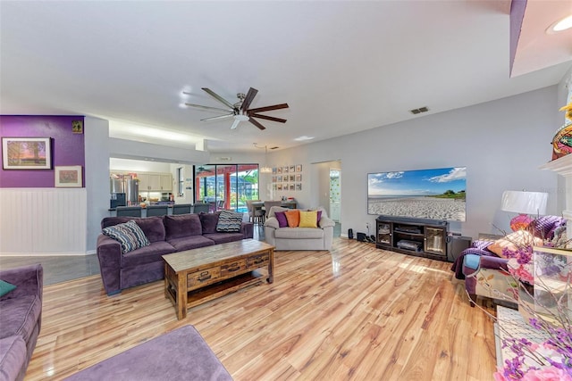 living room with ceiling fan and light hardwood / wood-style flooring