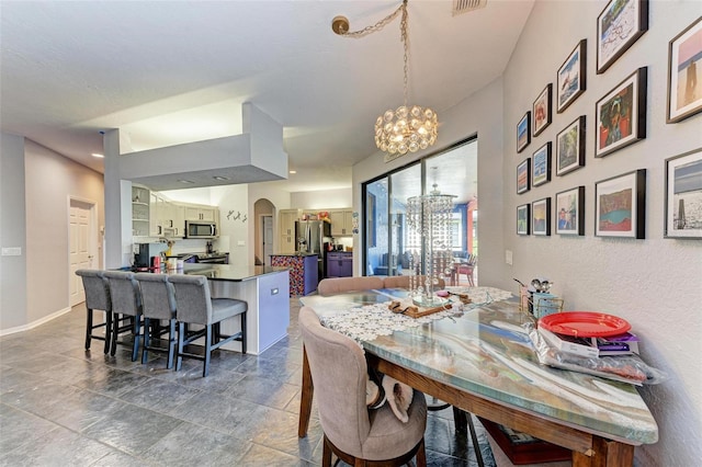 tiled dining space with a notable chandelier