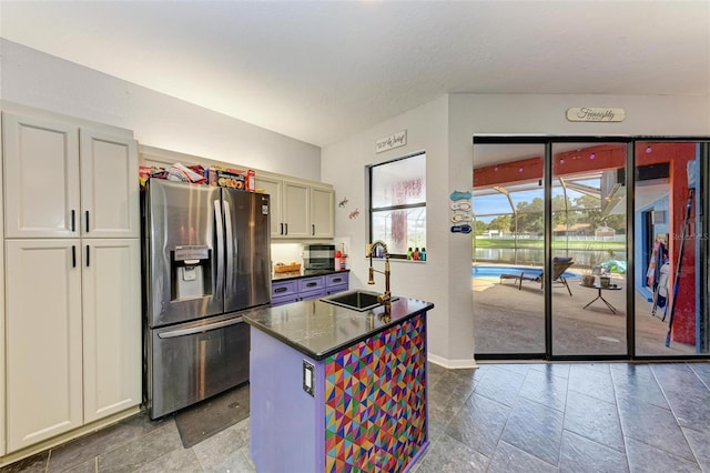 kitchen with sink, a center island, fridge, and tile patterned flooring