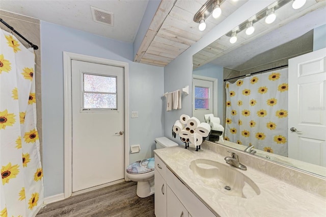 bathroom with toilet, vanity, and hardwood / wood-style flooring