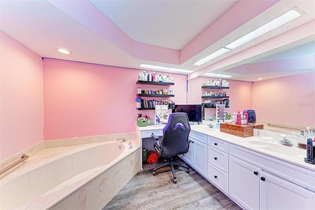 bathroom with hardwood / wood-style flooring, vanity, and a tub to relax in