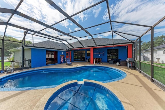 view of pool with glass enclosure, area for grilling, and a patio