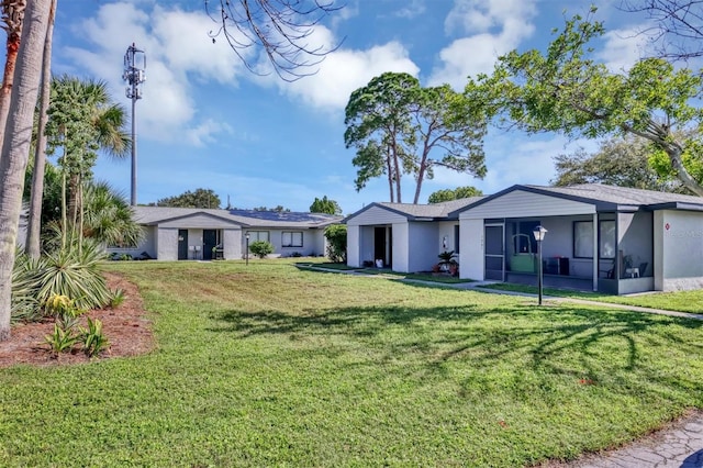 view of front of home with a front yard and a sunroom