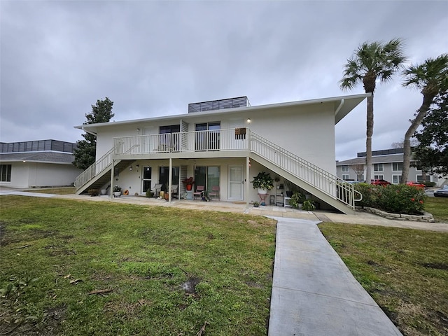 view of front of home featuring a front yard, a patio area, and a wooden deck