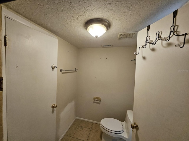 bathroom featuring tile patterned floors, toilet, and a textured ceiling