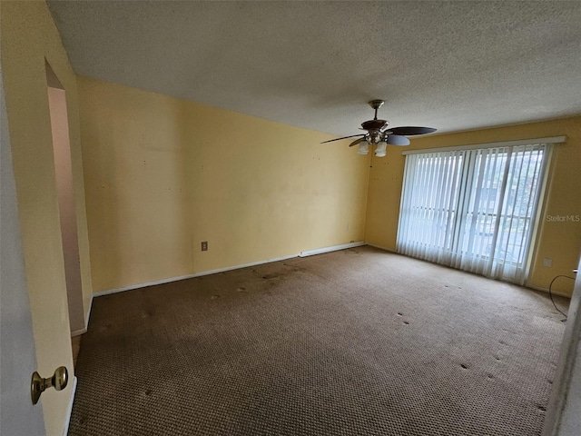 carpeted spare room featuring ceiling fan and a textured ceiling