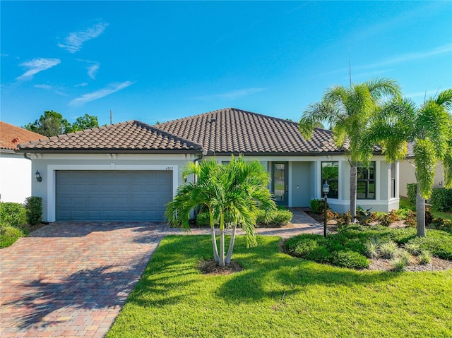 mediterranean / spanish home with a garage and a front yard