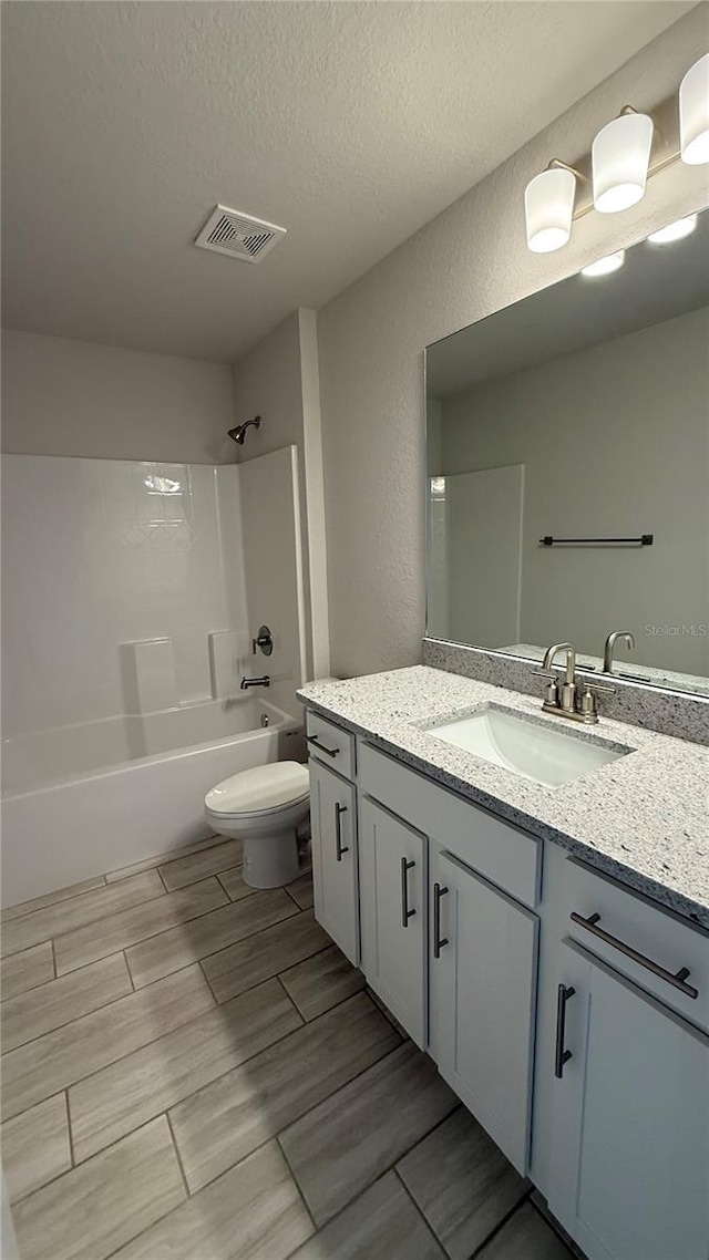 full bath with a textured ceiling, a textured wall, shower / bathing tub combination, and visible vents