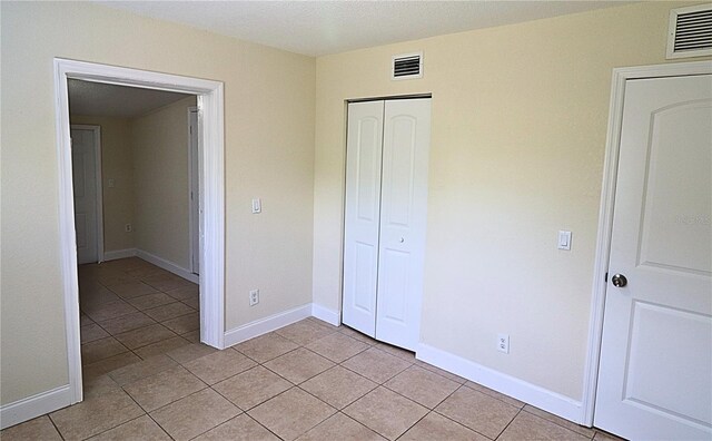 unfurnished bedroom featuring a closet and light tile patterned floors