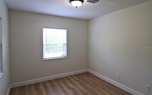 unfurnished room with wood-type flooring