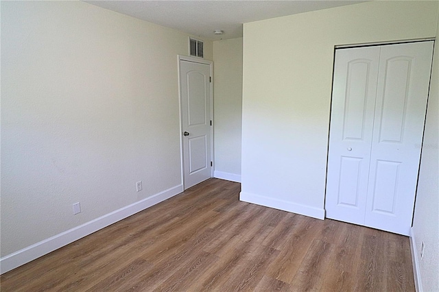 unfurnished bedroom featuring dark hardwood / wood-style floors and a closet