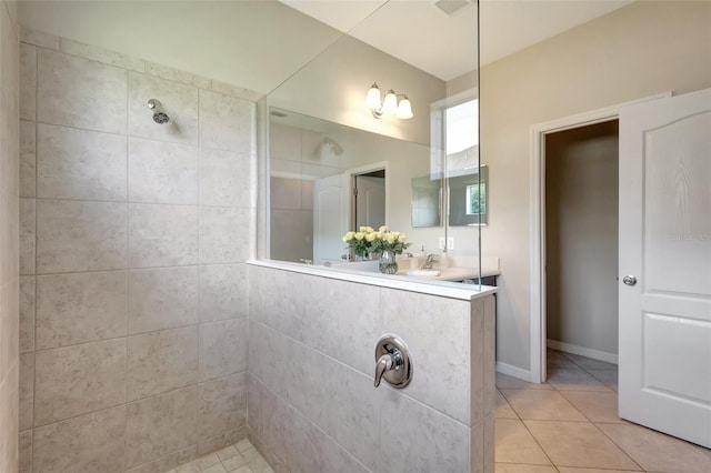 bathroom with a tile shower, tile patterned floors, and vanity