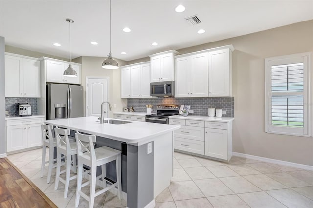 kitchen featuring stainless steel appliances, white cabinetry, and sink