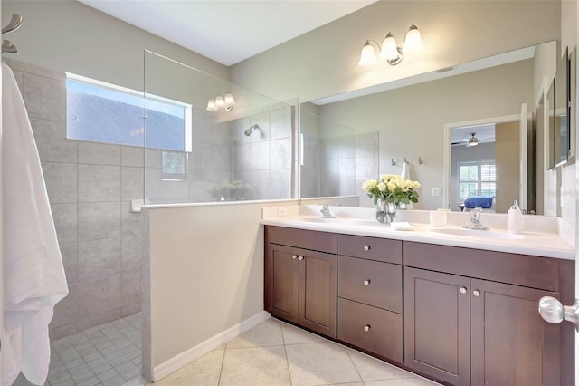 bathroom with ceiling fan, tile patterned flooring, vanity, and tiled shower