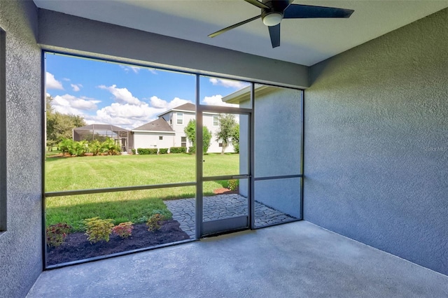 unfurnished sunroom with ceiling fan