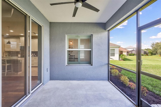 unfurnished sunroom featuring ceiling fan and sink