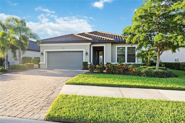 mediterranean / spanish-style house with a garage and a front lawn