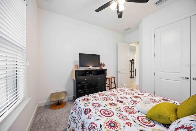 carpeted bedroom featuring ceiling fan and a closet