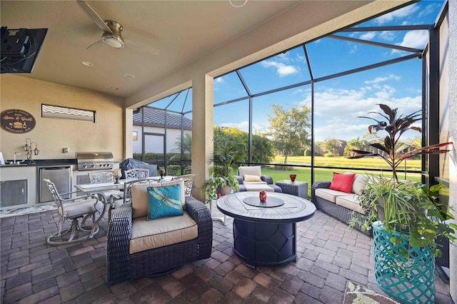 sunroom featuring ceiling fan and sink