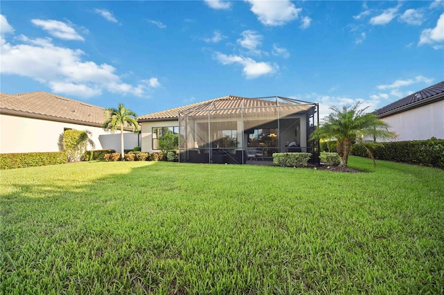 rear view of property with a yard and a lanai