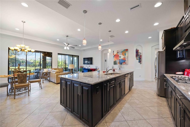 kitchen with pendant lighting, ceiling fan with notable chandelier, sink, and a kitchen island with sink