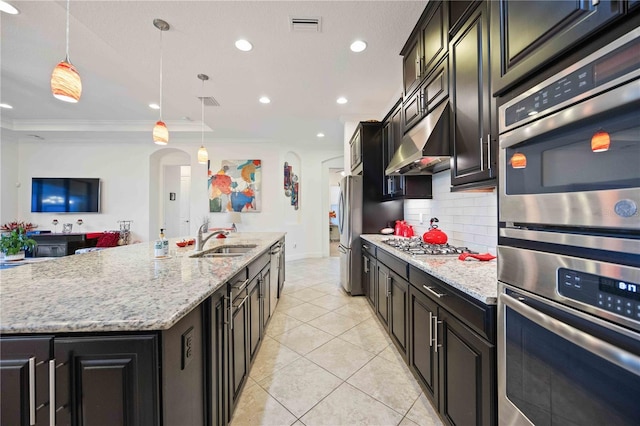 kitchen featuring sink, stainless steel appliances, an island with sink, pendant lighting, and ornamental molding