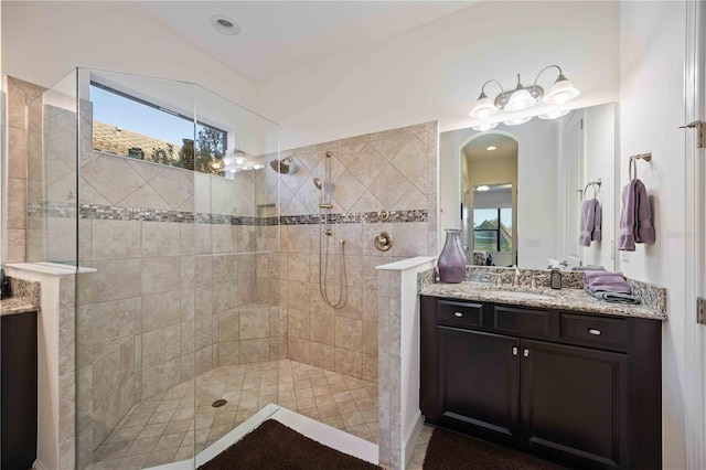 bathroom with a tile shower, vanity, and a wealth of natural light