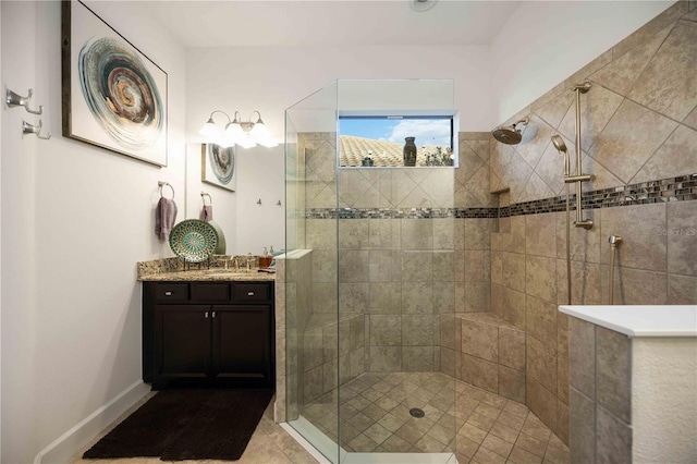 bathroom featuring a tile shower, tile patterned floors, and vanity