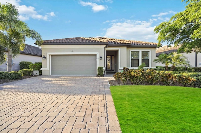 mediterranean / spanish-style home featuring a front yard and a garage