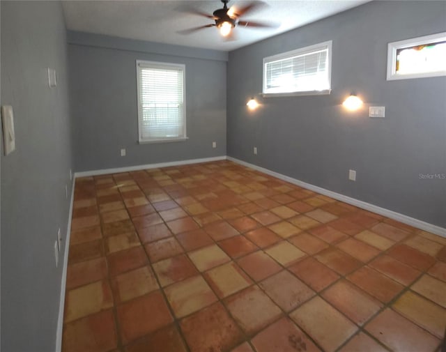 tiled spare room featuring ceiling fan and a healthy amount of sunlight