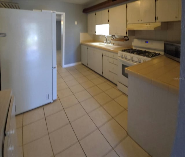 kitchen featuring backsplash, white appliances, sink, and light tile patterned floors